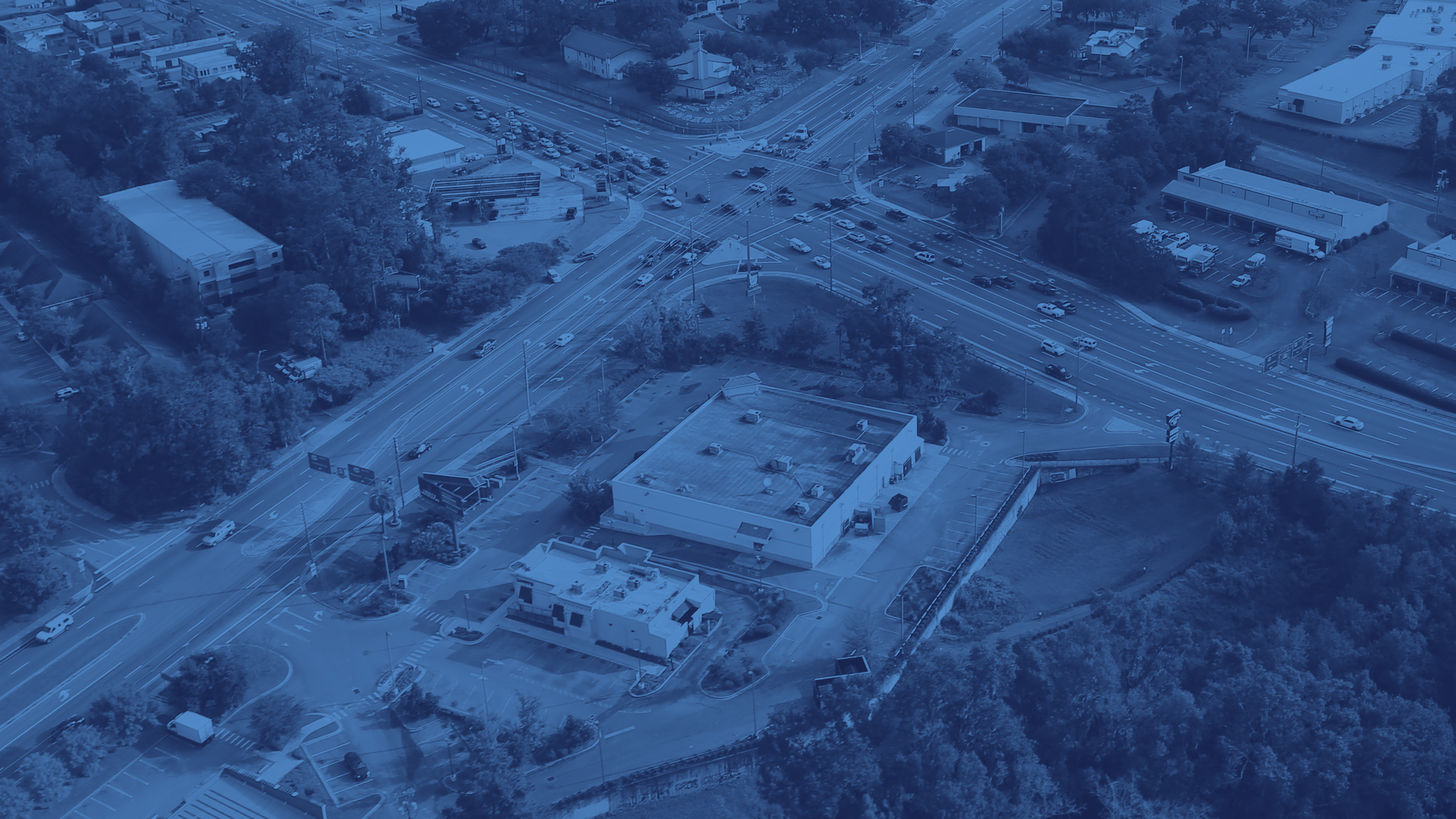Background photo: Monochrome blue aerial photo of a city intersection